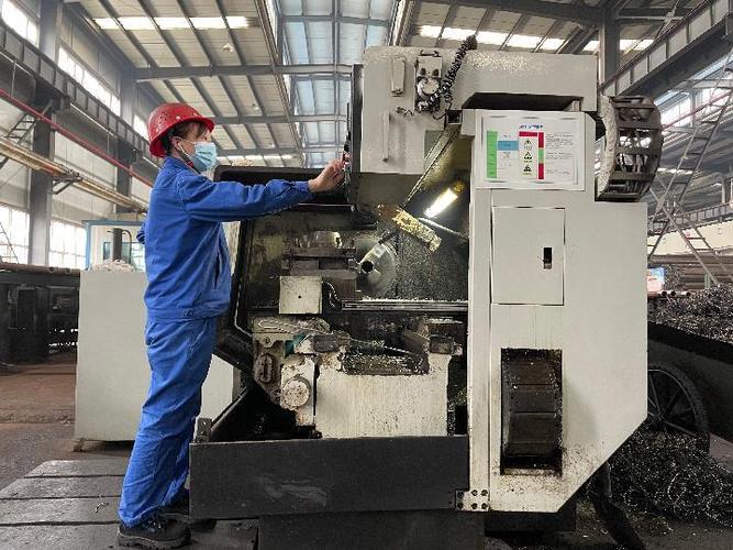 图为工人在陕西嘉盛石油机械的生产车间内操作设备.